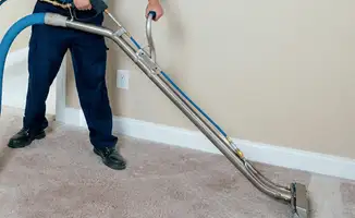 Professional operating a liquid removal machine on a carpeted floor in Columbia, MO